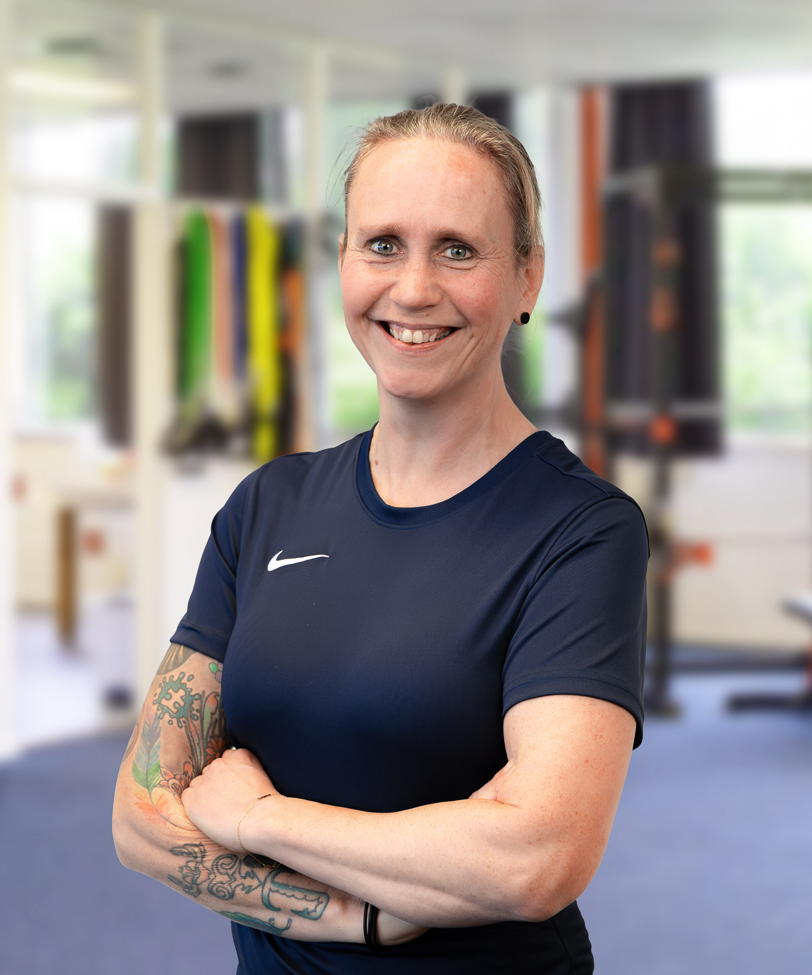Paula, groepsles docent bij EERLIJK FIT, met de armen over elkaar in de studio